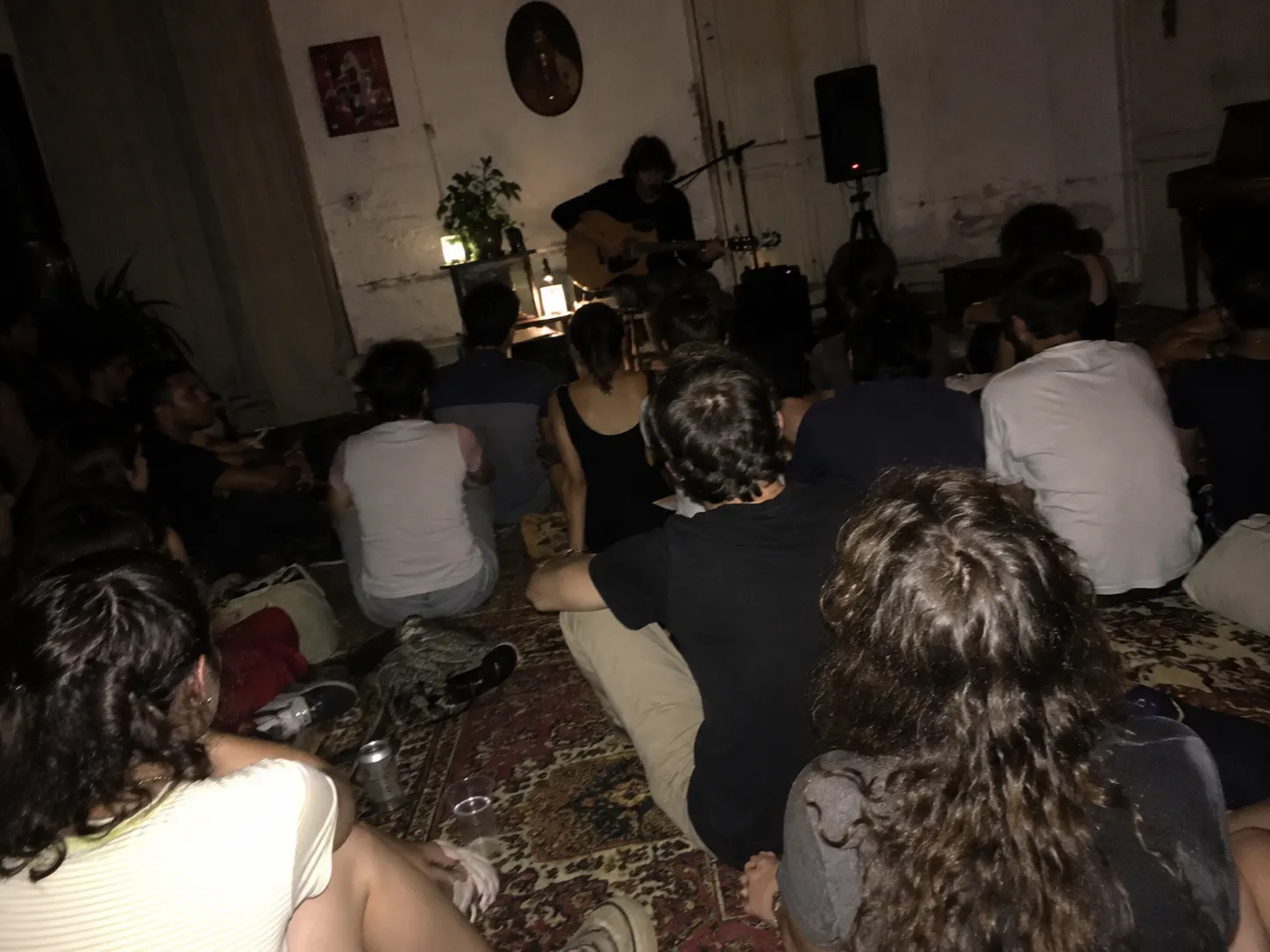 Serata intima con candele e pubblico seduto sul tappeto